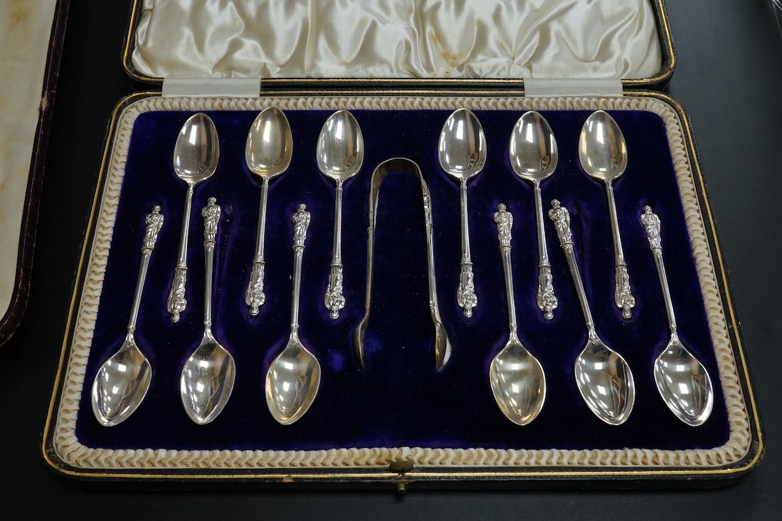 A cased set of twelve Edwardian silver apostle teaspoons with a pair of sugar tongs, Cooper Brothers & Sons, Sheffield, together with a cased Victorian silver bread knife and a cased set of six silver handled steel tea k